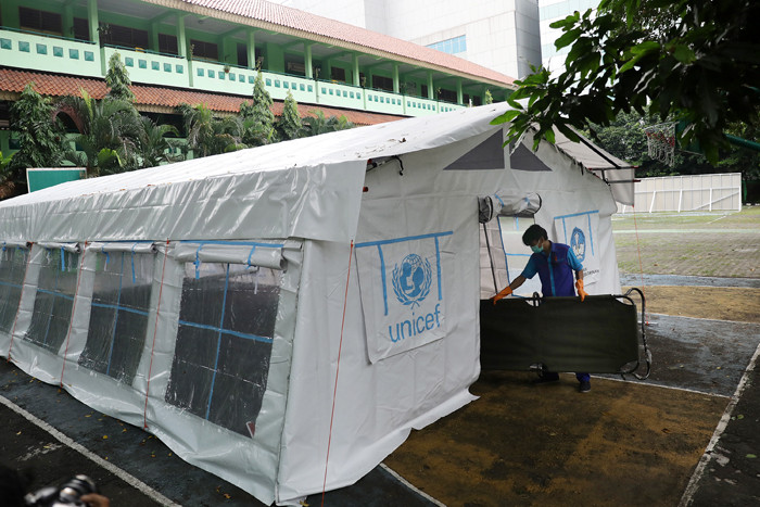 Pekerja RSUD Tarakan menyiapkan velbed di tenda darurat di SDN Negeri 02 Cideng, Jakarta, Selasa (29/6/2021).