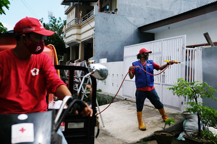Petugas Palang Merah Indonesia menyemprotkan disinfektan ke rumah warga di Kelurahan Minasa Upa, Makassar, Rabu (30/6/2021).