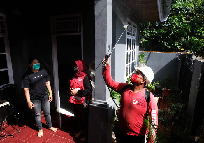 Petugas Palang Merah Indonesia menyemprotkan disinfektan ke rumah warga di Kelurahan Minasa Upa, Makassar, Rabu (30/6/2021).