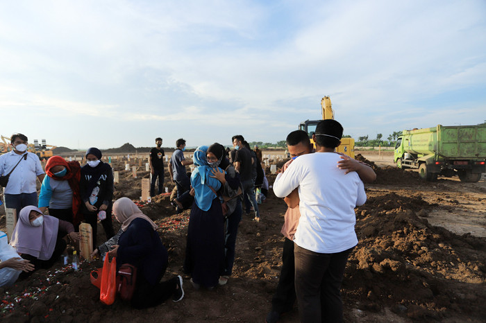 Petugas memakamkan jenazah dengan protokol Covid-19 di TPU Rorotan, Cilincing, Jakarta Utara, Rabu (30/6/2021).