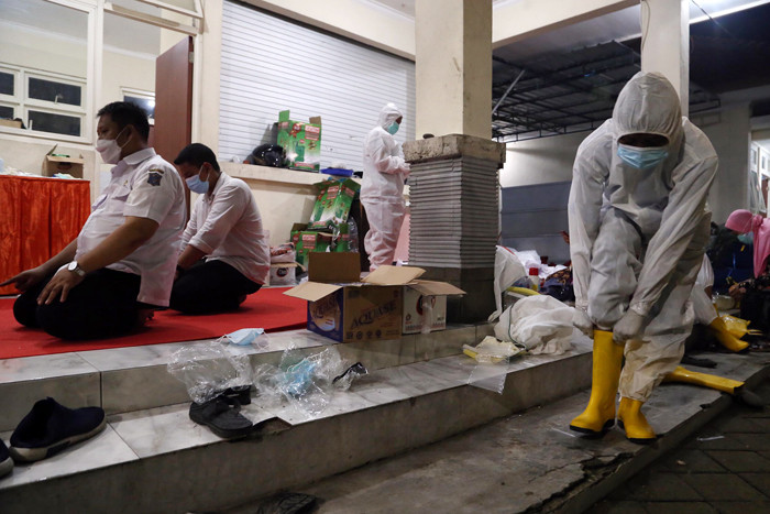 Para Modin saling membantu mengenakan alat pelindung diri (APD) lengkap di tempat pemulasaraan darurat Keputih Surabaya, Rabu (30/6/2021).
