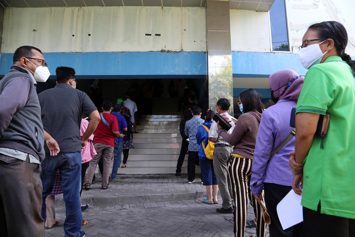 Warga mendapatkan suntikan vaksin Covid-19 saat mengikuti vaksinasi massal di Auditorium Poltekkes Kemenkes Surabaya, Jawa Timur, Rabu (30/6/2021).