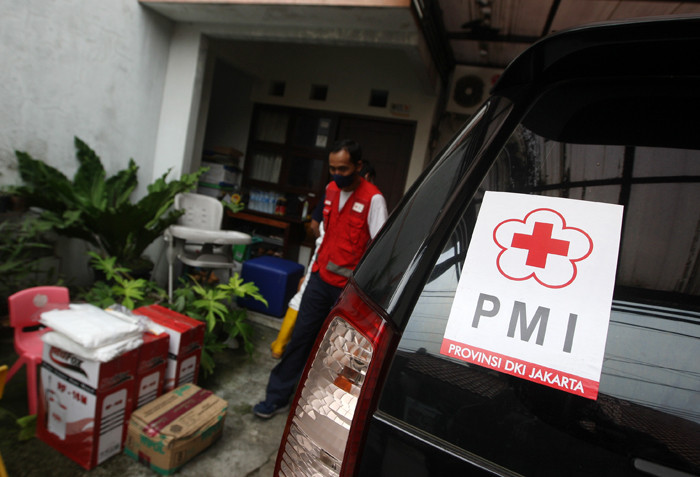 Petugas Palang Merah Indonesia Jaktim saat melakukan penyemprotan cairan disinfektan ke rumah warga di Kelurahan Tengah, Jakarta Timur, Kamis (1/7/2021).