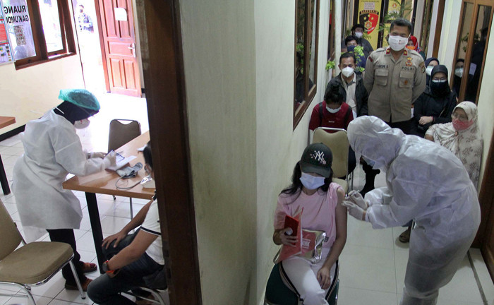 Petugas menyuntikkan vaksin Covid-19 Sinovac kepada warga di Mapolsek Pamulang, Tangerang Selatan, Banten, Kamis (1/7/2021).