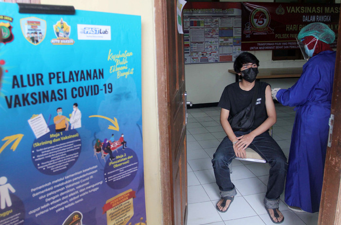 Petugas menyuntikkan vaksin Covid-19 Sinovac kepada warga di Mapolsek Pamulang, Tangerang Selatan, Banten, Kamis (1/7/2021).