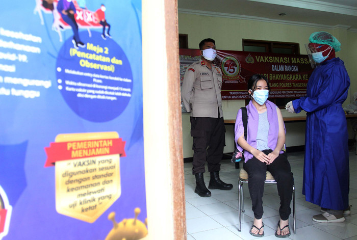 Petugas menyuntikkan vaksin Covid-19 Sinovac kepada warga di Mapolsek Pamulang, Tangerang Selatan, Banten, Kamis (1/7/2021).