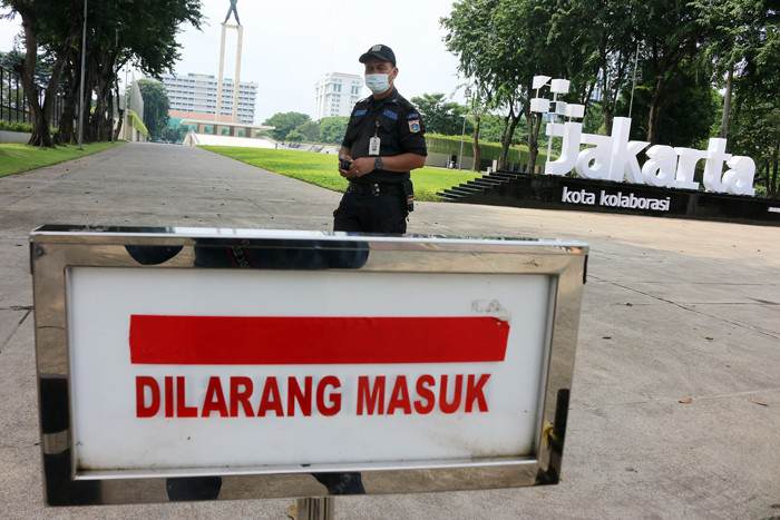 Petugas Satpol PP berjaga dikawasan taman kota lapangan banteng yang ditutup sementara oleh Pemprov DKI Jakarta, Kamis (1/7/2021).