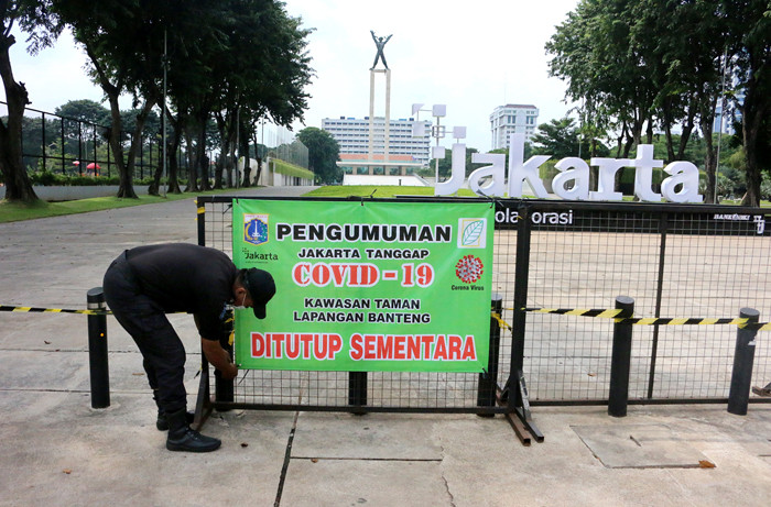 Petugas Satpol PP berjaga dikawasan taman kota lapangan banteng yang ditutup sementara oleh Pemprov DKI Jakarta, Kamis (1/7/2021).