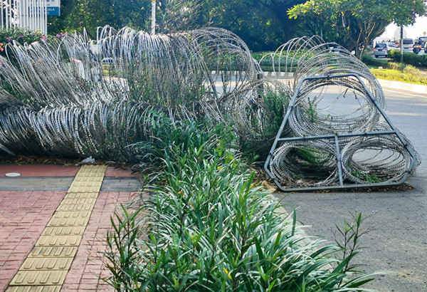 Pejalan kaki saat melintas menghindari kawat pengamanan yang sudah tidak terpakai di kawasan Jalan Gatot Subroto, Jakarta, Jumat (2/7/2021).