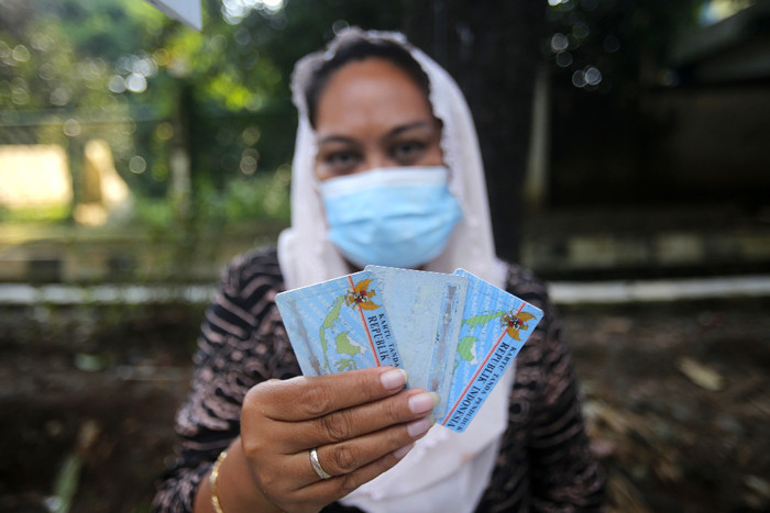 Ade Kalsum (46) tengah memperbaiki KTP elektronik milik warga di Jalan M Kahfi II, Jagakarsa, Jakarta Selatan, Jumat (2/7/2021).