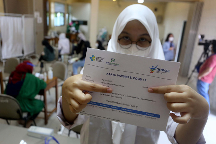 Siswa menunjukan kartu vaksinasi Covid-19 di SMK Negeri 15 Jakarta, Jumat (2/7/2021).