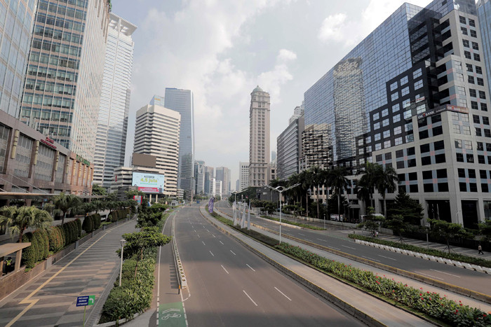 Suasana kawasan Jalan Sudirman tampak lengang hari pertama Pemberlakuan Pembatasan Kegiatan Masyarakat Darurat di Jakarta, Sabtu (3/7/2021).