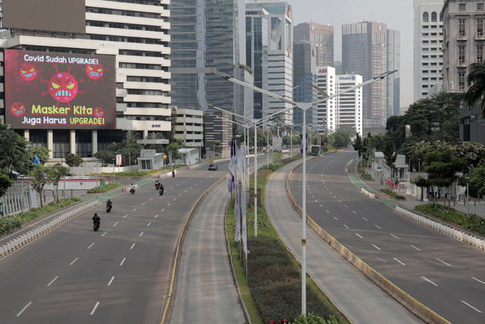 Suasana kawasan Jalan Sudirman tampak lengang hari pertama Pemberlakuan Pembatasan Kegiatan Masyarakat Darurat di Jakarta, Sabtu (3/7/2021).