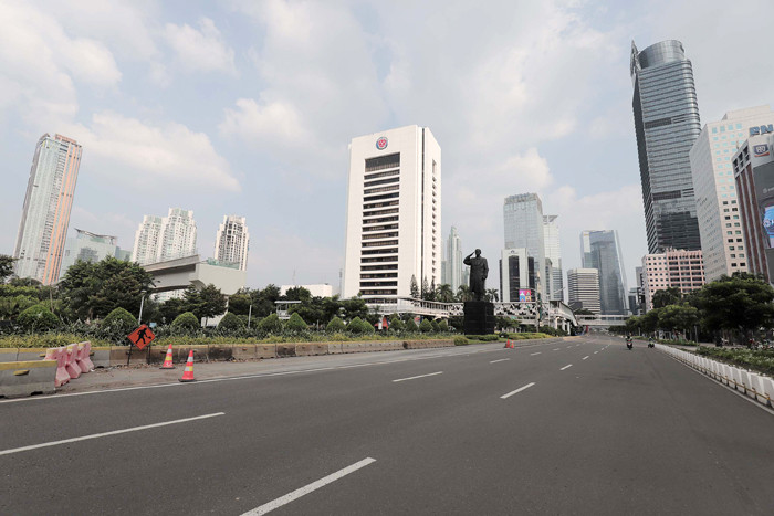Suasana kawasan Jalan Sudirman tampak lengang hari pertama Pemberlakuan Pembatasan Kegiatan Masyarakat Darurat di Jakarta, Sabtu (3/7/2021).