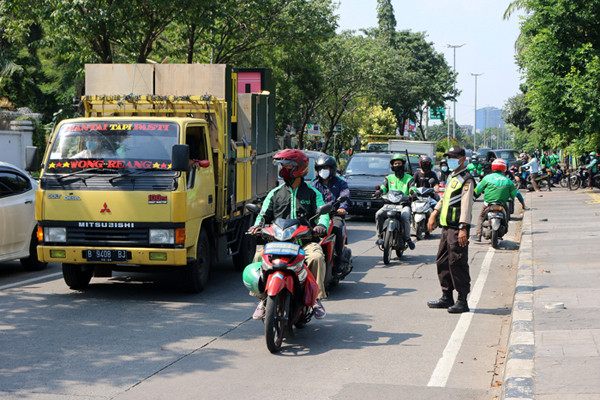 Petugas kepolisian melakukan penyekatan bagi para pengendara roda dua atau roda empat yang melintas di Jalan Danau Sunter, Jakarta, Sabtu (3/7/2021).