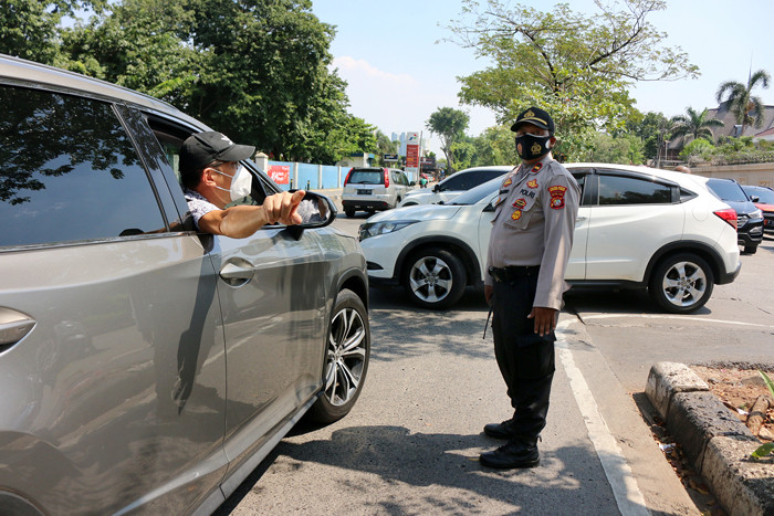 Petugas kepolisian melakukan penyekatan bagi para pengendara roda dua atau roda empat yang melintas di Jalan Danau Sunter, Jakarta, Sabtu (3/7/2021).