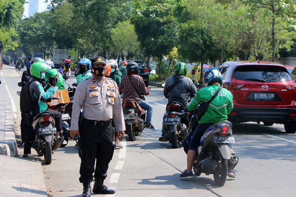 Petugas kepolisian melakukan penyekatan bagi para pengendara roda dua atau roda empat yang melintas di Jalan Danau Sunter, Jakarta, Sabtu (3/7/2021).