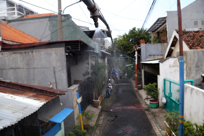 Semprotan disinfektan otomatis melintang di perkampungan Kampung Kranggan RT 7 RW 1 Kota Surabaya, Jawa Timur, Minggu (4/7/2021).