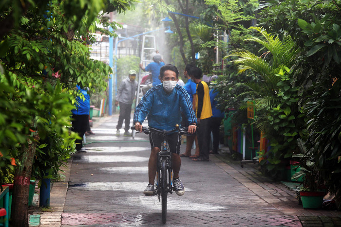 Semprotan disinfektan otomatis melintang di perkampungan Kampung Kranggan RT 7 RW 1 Kota Surabaya, Jawa Timur, Minggu (4/7/2021).