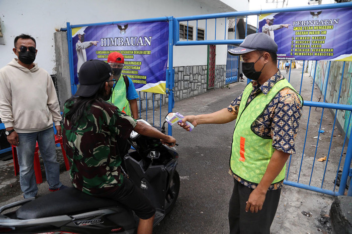 Semprotan disinfektan otomatis melintang di perkampungan Kampung Kranggan RT 7 RW 1 Kota Surabaya, Jawa Timur, Minggu (4/7/2021).