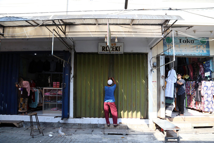 Petugas gabungan menyisir Pedagang Kali Lima (PKL) dan pertokoan dikawasan Wisata Religi Sunan Ampel Surabaya, Jawa Timur, Minggu (4/7/2021).