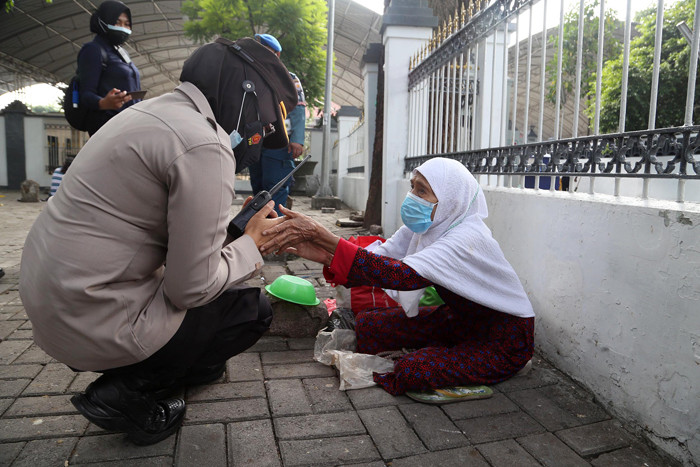 Para peziarah meninggalkan area makam usai berdoa ketika didatangi aparat gabungan di kawasan Makan Sunan Ampel Surabaya, Jawa Timur, Minggu (4/7/2021).