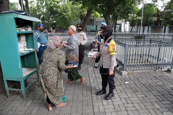 Para peziarah meninggalkan area makam usai berdoa ketika didatangi aparat gabungan di kawasan Makan Sunan Ampel Surabaya, Jawa Timur, Minggu (4/7/2021).