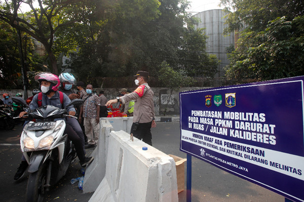 Petugas gabungan dari TNI, Polri, Satpol PP dan Dinas Perhubungan memutar balikan pengendara di Pos Penyekatan, Jalan Raya Daan Mogot, Senin (5/7/2021).