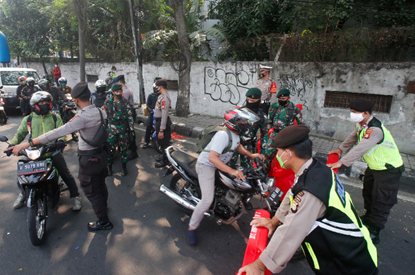 Petugas gabungan dari TNI, Polri, Satpol PP dan Dinas Perhubungan memutar balikan pengendara di Pos Penyekatan, Jalan Raya Daan Mogot, Senin (5/7/2021).