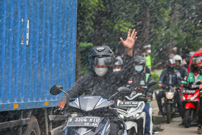Petugas Pemadam Kebakaran meyemprotkan cairan disinfektan ke pengendara di Jalan Raya Lenteng Agung, Jakarta Selatan, Senin (5/7/2021).
