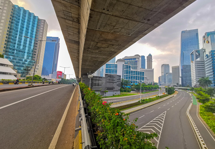 Suasana Jalan Sudirman terlihat lengang pada hari kedua PPKM darurat di Jakarta Pusat, Minggu (4/7/2021).