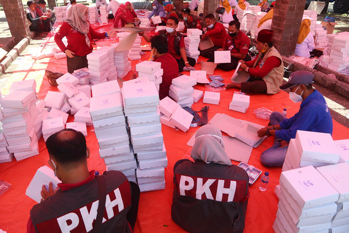 Para relawan memasak di dapur umum Kementerian Sosial di area halaman Convention Hall Surabaya, Jawa Timur, Senin (5/7/2021).