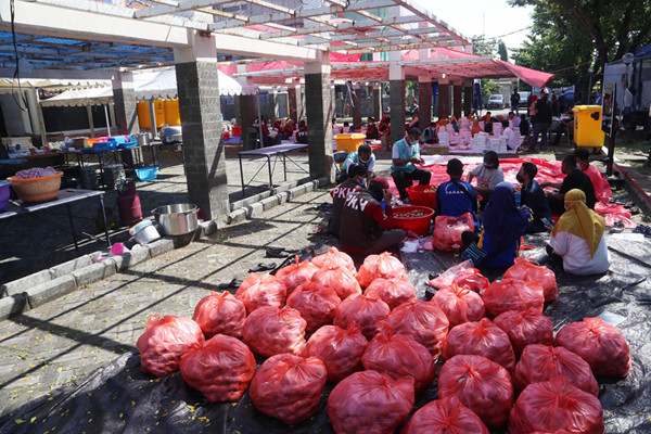 Para relawan memasak di dapur umum Kementerian Sosial di area halaman Convention Hall Surabaya, Jawa Timur, Senin (5/7/2021).