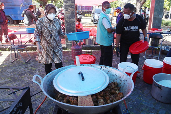 Mensos Tri Rismaharini ikut memasak untuk para pejuang Covid-19 di Dapur Umum di area halaman Convention Hall Surabaya, Jawa Timur, Senin (5/7/2021).