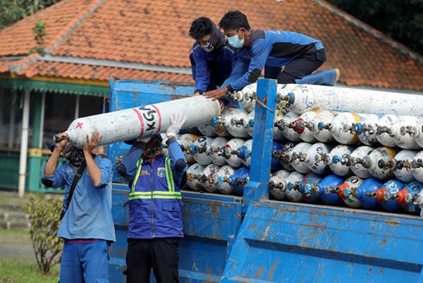 Sejumlah petugas menurunkan tabung berisi oksigen dari truk di Posko Darurat Oksigen Rescue di kawasan Monumen Nasional, Jakarta, Senin (5/7/2021).