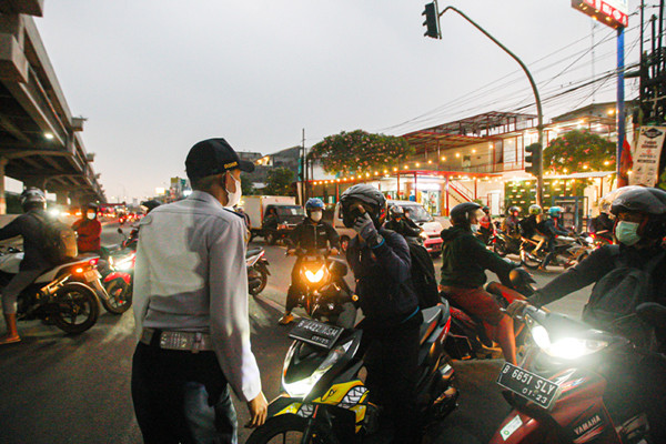 Petugas berjaga di barikade penyekatan PPKM Darurat di Pos Lampiri Kalimalang, Jakarta Timur, Senin (5/7/2021).