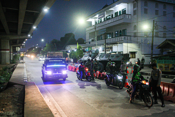 Petugas berjaga di barikade penyekatan PPKM Darurat di Pos Lampiri Kalimalang, Jakarta Timur, Senin (5/7/2021).