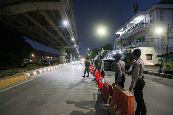 Petugas berjaga di barikade penyekatan PPKM Darurat di Pos Lampiri Kalimalang, Jakarta Timur, Senin (5/7/2021).