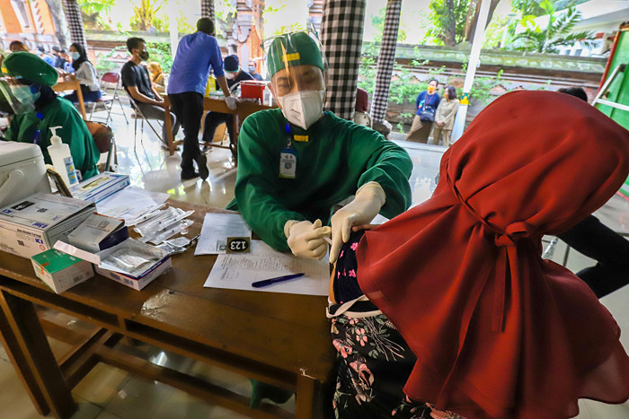 Warga saat mengikuti vaksinasi massal Covid-19 di rumah ibadah Pure Candra Prabha, Jakarta Barat, Senin (5/7/2021).