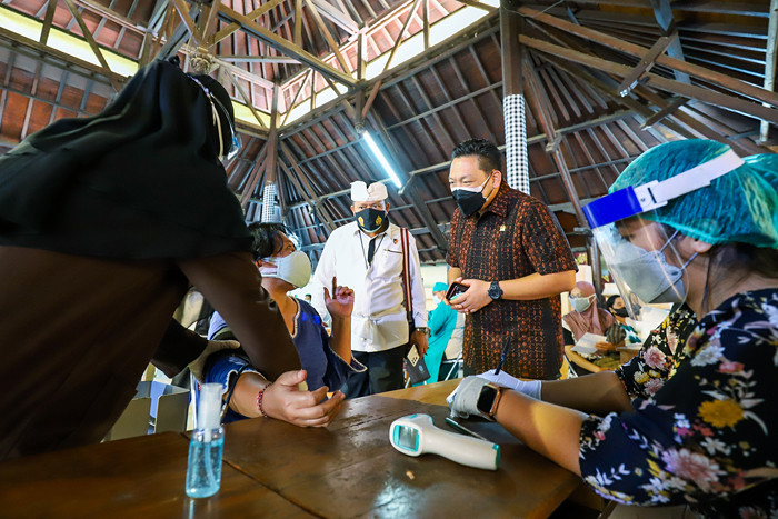 Warga saat mengikuti vaksinasi massal Covid-19 di rumah ibadah Pure Candra Prabha, Jakarta Barat, Senin (5/7/2021).