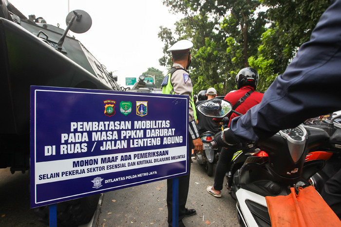 Petugas Brimob saat melakukan pemeriksaan warga yang melewati pos penyekatan PPKM Darurat di Lenteng Agung, Jakarta Selatan, Selasa (6/7/2021).