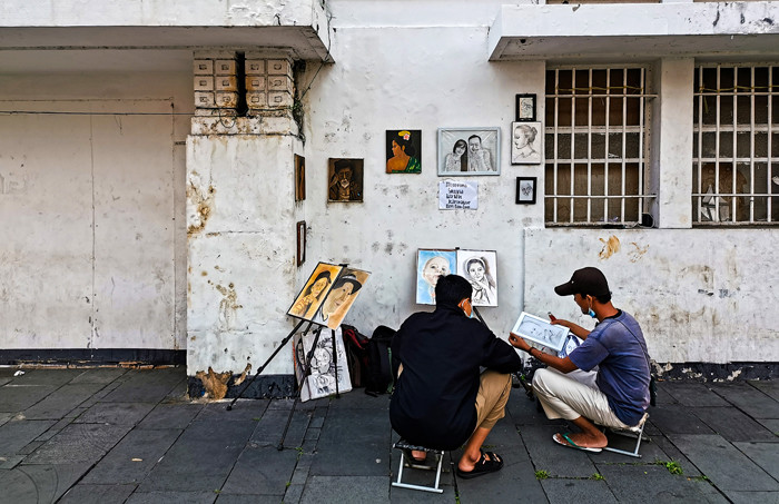 Jasa pembuat sketsa wajah sedang menyelesaikan pesanannya di kawasan Kota Tua, Jakarta Barat, Selasa (6/7/2021).