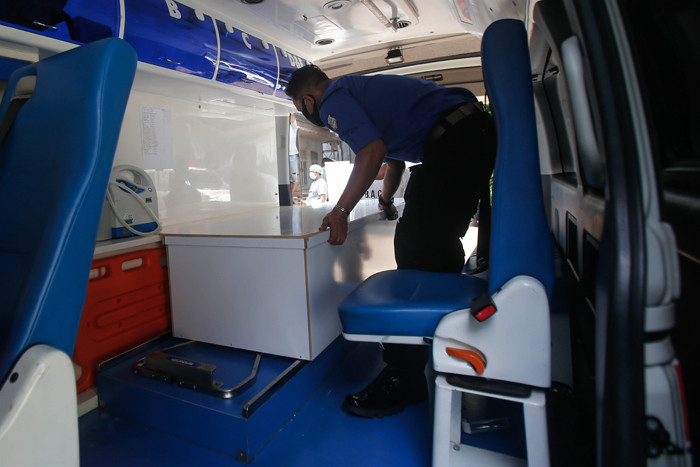Pekerja mengangkat peti mati untuk dipindahkan ke ambulans di TPU Petamburan, Jakarta Pusat, Selasa (6/7/2021).
