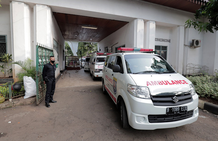 Pekerja mengangkut peti jenazah ke dalam ambulans untuk didistribusikan di TPU Petamburan, Jakarta Pusat, Selasa (6/7/2021).
