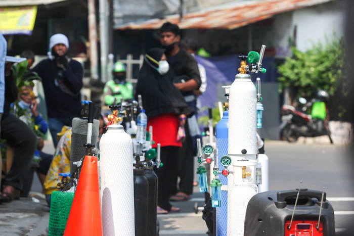 Karyawan toko saat memberikan arahan kepada warga yang akan mengisi ulang tabung oksigen di kawasan Manggarai, Jakarta Selatan, Selasa (6/7/2021).
