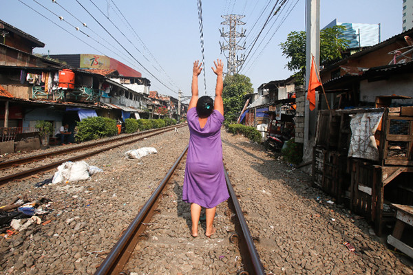 Warga berjemur di dekat jalur kereta api di kawasan Pejompongan, Jakarta Pusat, Selasa (6/7/2021).