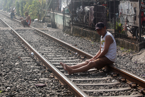 Warga berjemur di dekat jalur kereta api di kawasan Pejompongan, Jakarta Pusat, Selasa (6/7/2021).