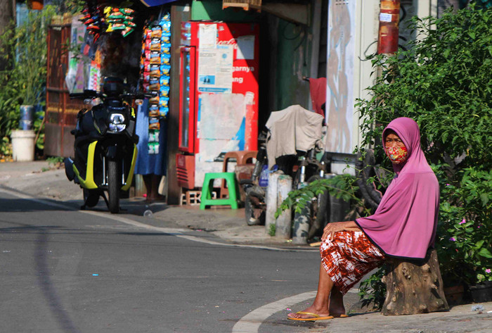 Warga berjemur dan melakukan olahraga didepan halaman rumah mereka di kawasan Serdang Kemayoran, Jakarta, Rabu (7/7/2021).
