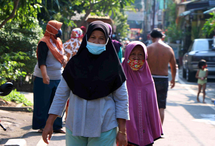 Warga berjemur dan melakukan olahraga didepan halaman rumah mereka di kawasan Serdang Kemayoran, Jakarta, Rabu (7/7/2021).