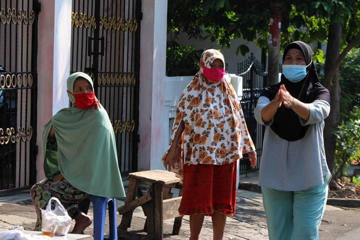 Warga berjemur dan melakukan olahraga didepan halaman rumah mereka di kawasan Serdang Kemayoran, Jakarta, Rabu (7/7/2021).